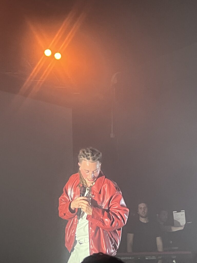 Sayf durante il live con giacca di pelle rossa